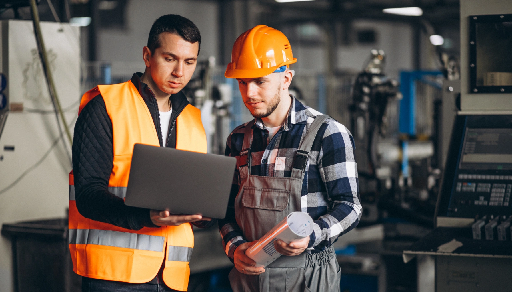 Man using tablet in industrial setting, showcasing field service management